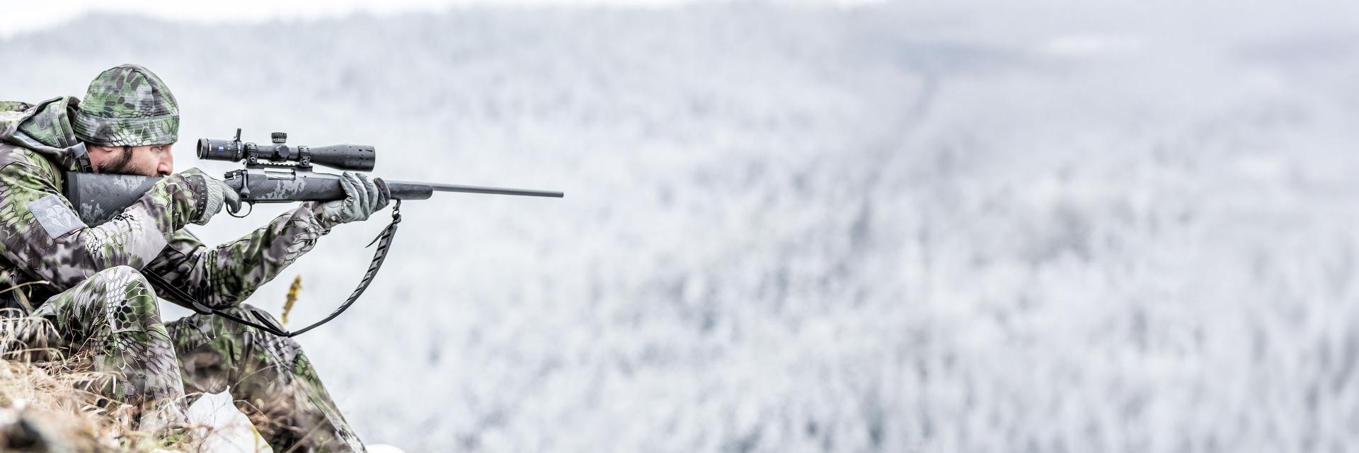 Sunglasses with ZEISS lenses lying on a blue table, reflecting a smiling woman, next to a smartphone and a glass of water.
