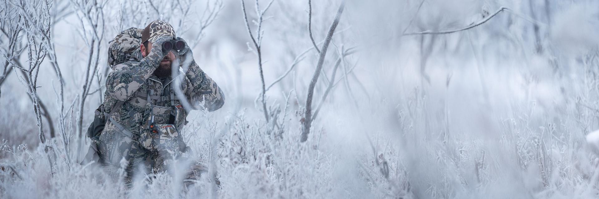 Sunglasses with ZEISS lenses lying on a blue table, reflecting a smiling woman, next to a smartphone and a glass of water.