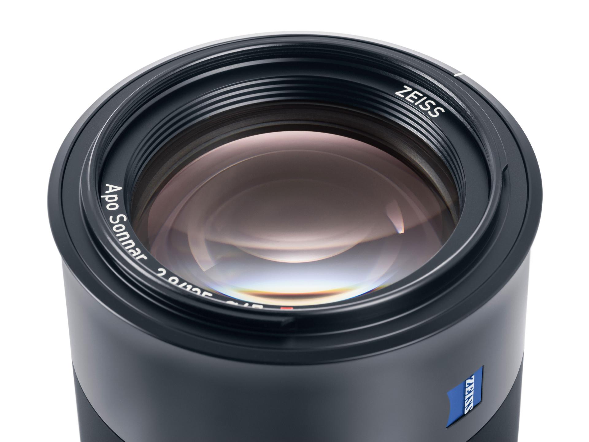 Close-up view of a ZEISS Apo Sonnar 2/135 camera lens with visible branding and lens details.