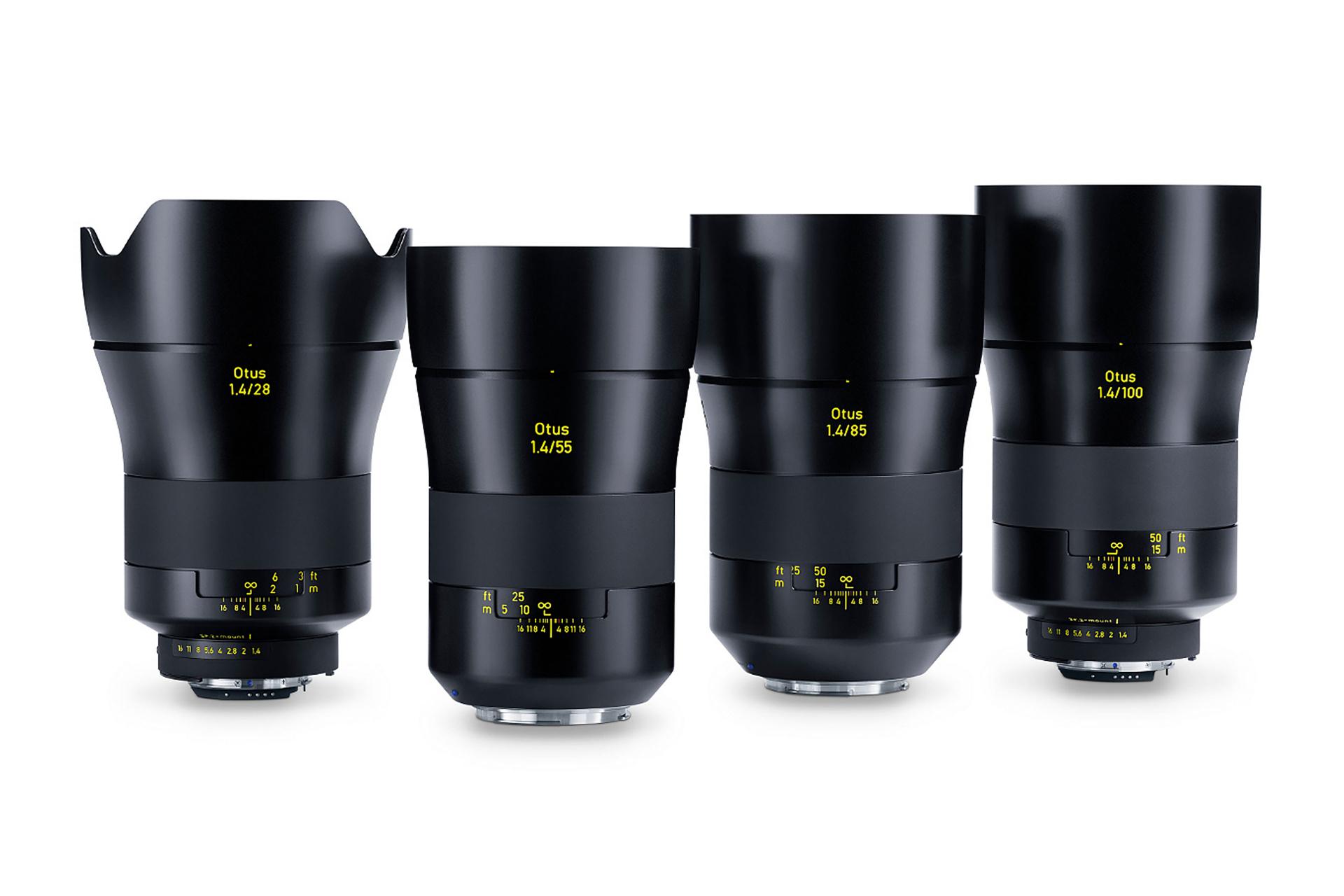 Four ZEISS Otus camera lenses with varying focal lengths are displayed standing upright in a row on a white background.