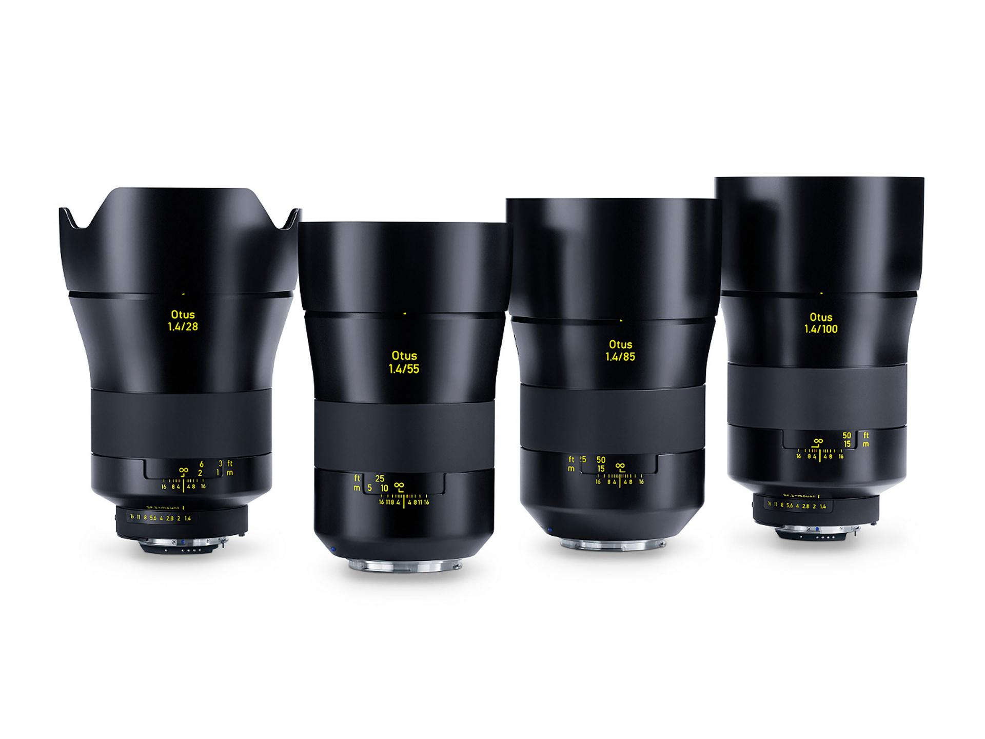 Four ZEISS Otus camera lenses with varying focal lengths are displayed standing upright in a row on a white background.