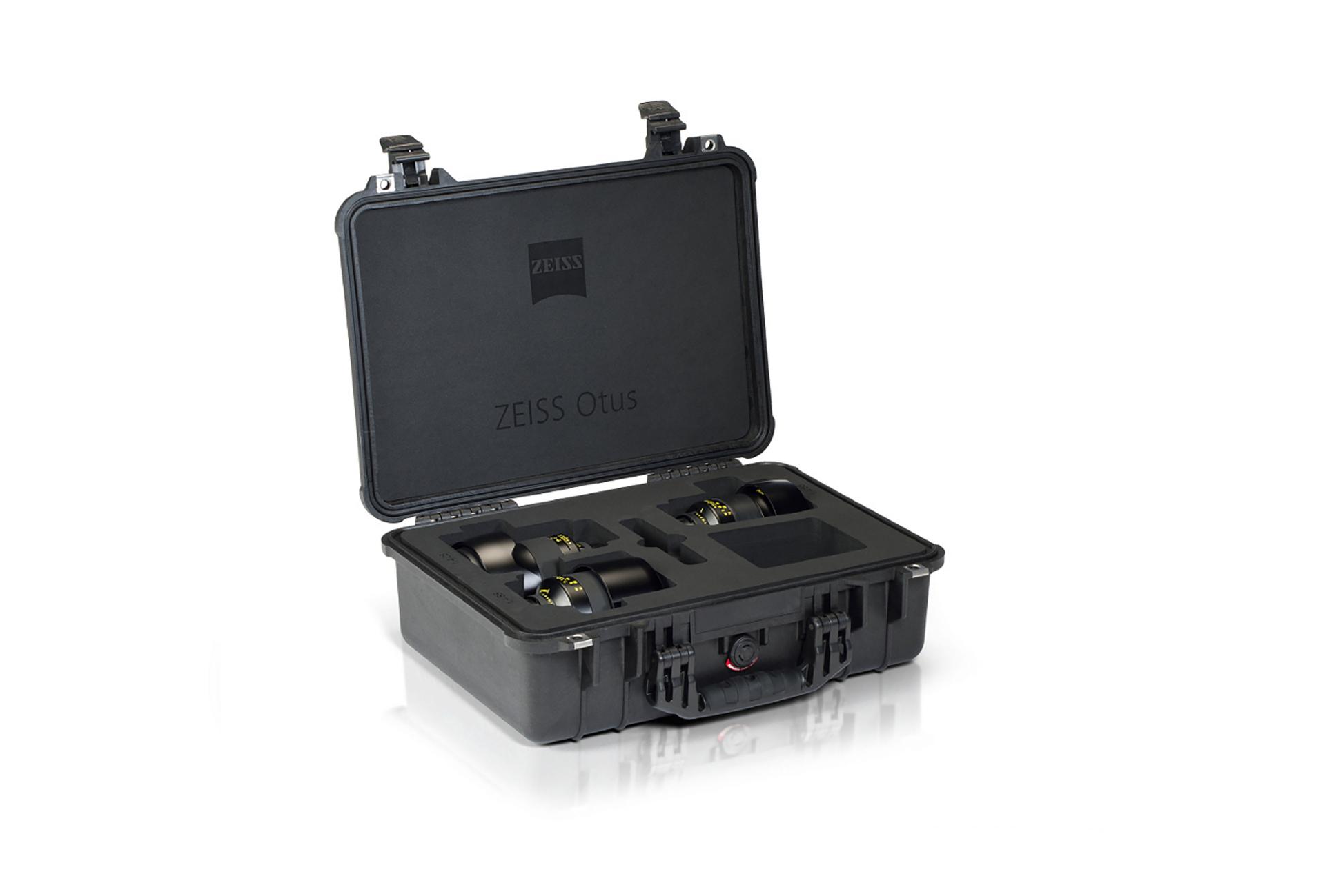 Black hard-shell case with custom foam insert holding four ZEISS Otus camera lenses, with the case lid open displaying the ZEISS logo.