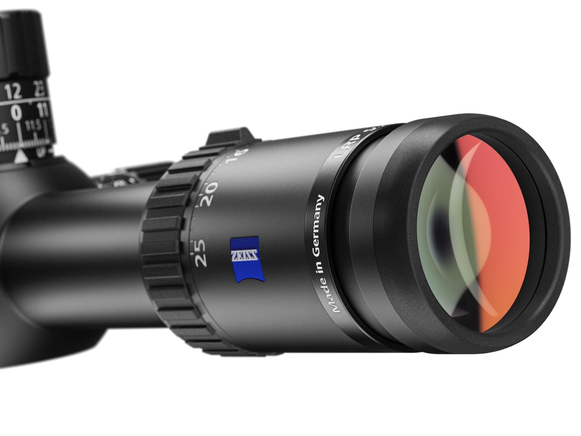 Close-up view of a ZEISS riflescope featuring a zoom adjustment ring, engraved markings, and a visible multi-coated lens with the ZEISS logo.