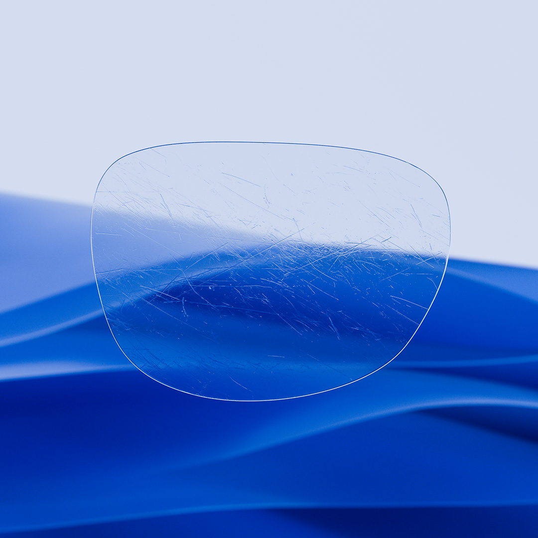 Una lente partida con un lado transparente con ZEISS DuraVision y un lado con arañazos sobre la lente.