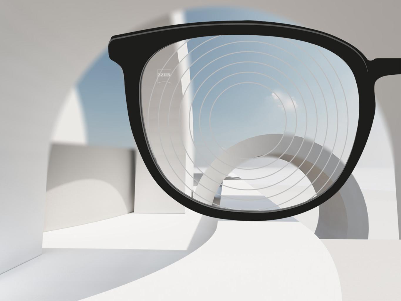 Imagen en primer plano de las lentes de control de la miopía de ZEISS, con montura de gafas negra y círculos concéntricos en la superficie de la lente.
