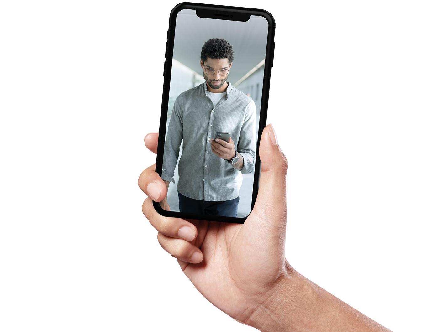 Un smartphone muestra a un joven de pelo corto caminando y con las lentes ZEISS SmartLife.