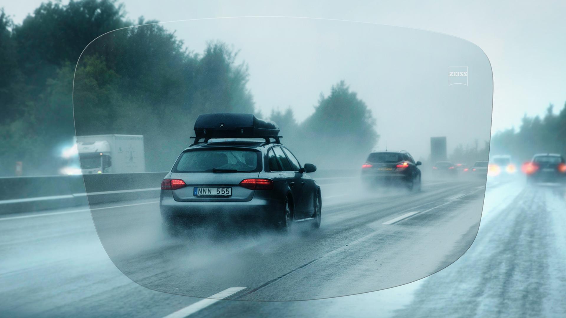 Vista a través de una lente monofocal ZEISS DriveSafe Individual de una carretera en un día de lluvia 