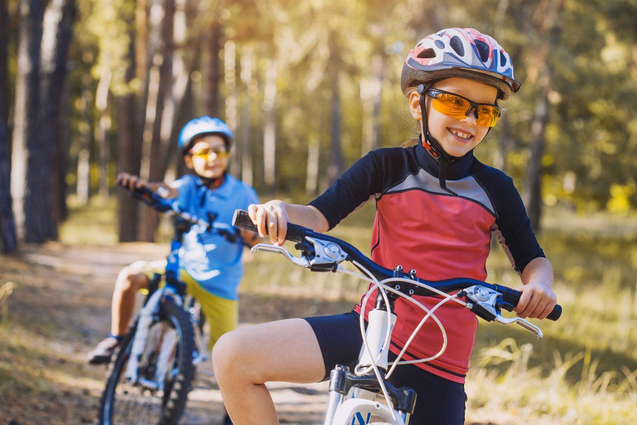 Loremipsum Niños en bicicleta al aire libre con casco
