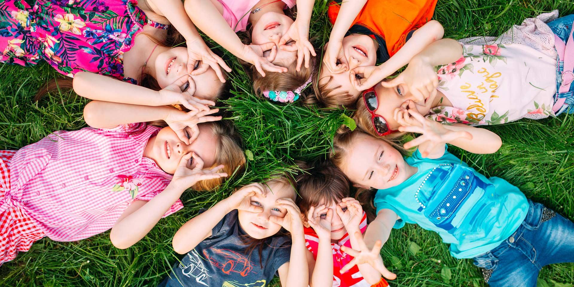 Un grupo de niños tumbados sobre el césped del parque. La interacción de los niños.