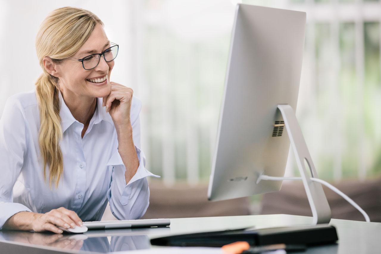 Mujer mirando la pantalla del ordenador con las gafas puestas