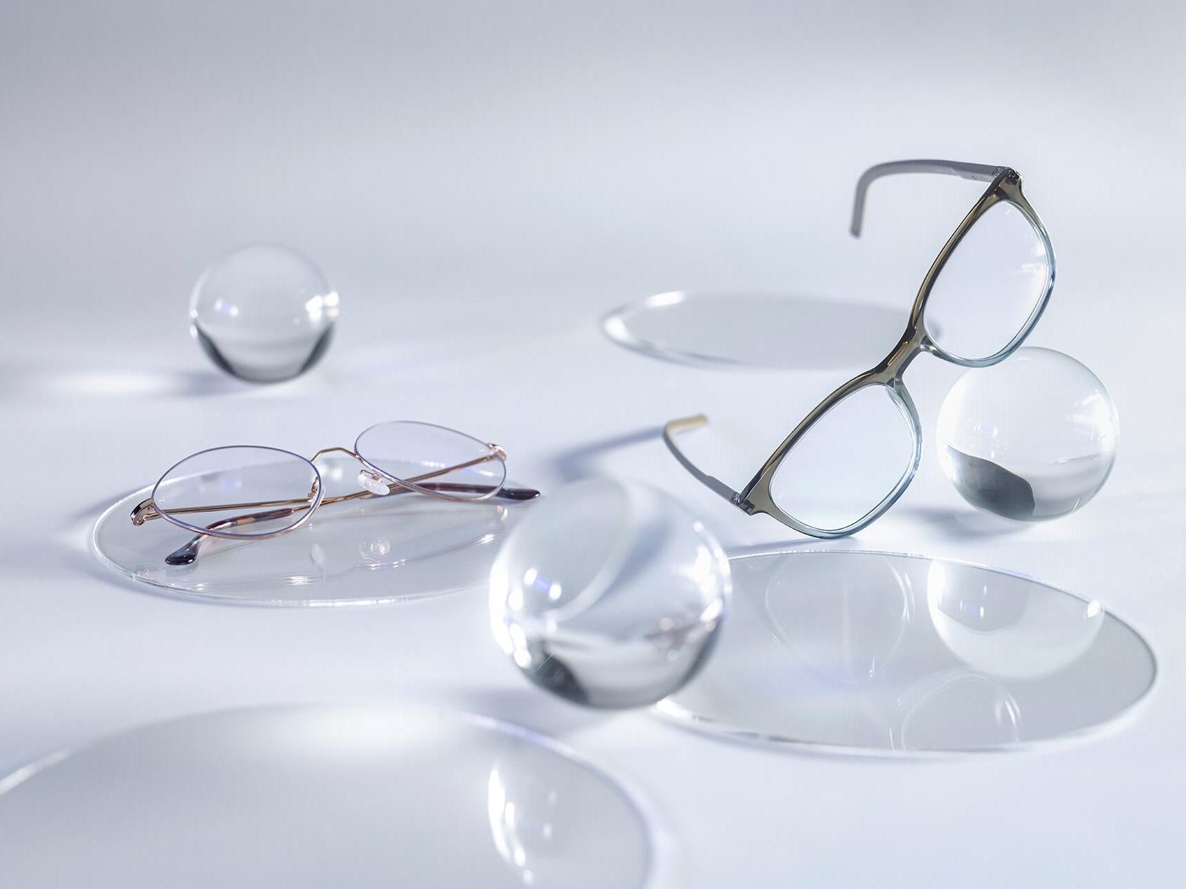 Gafas con lentes ZEISS y el tratamiento DuraVision® Silver, que no muestran reflejos en comparación con las esferas de cristal que las rodean.