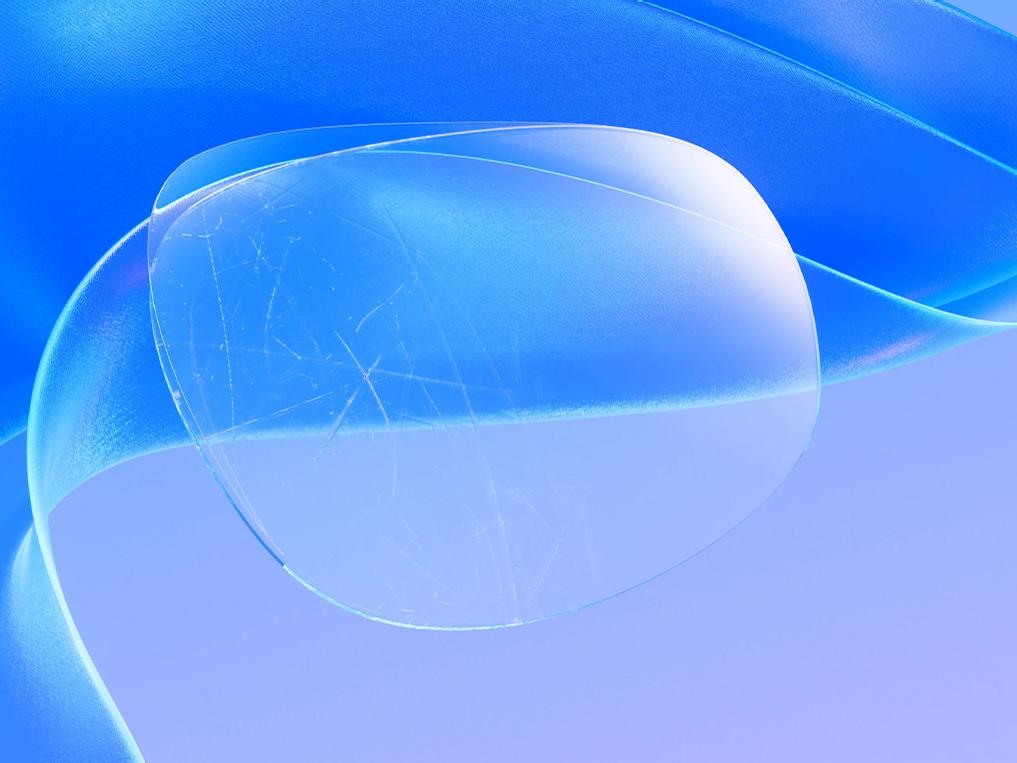 Representación 3D CGI de una lente rayada, sobre la que se aplica un fino protector que oculta eficazmente los arañazos, lo que logra una superficie de la lente clara e impecable.