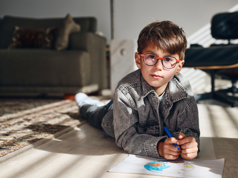 Un joven con lentes ZEISS MyoCare mira directamente a la cámara.