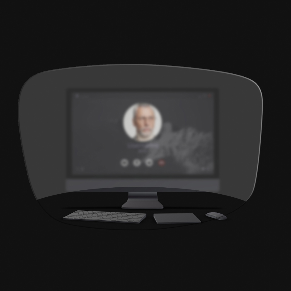 La vista de un ordenador de sobremesa, un teclado, un ratón y un libro a través de un esquema de unas gafas de lectura muestra que solo los objetos cercanos son claramente visibles. La pantalla del ordenador está borrosa.