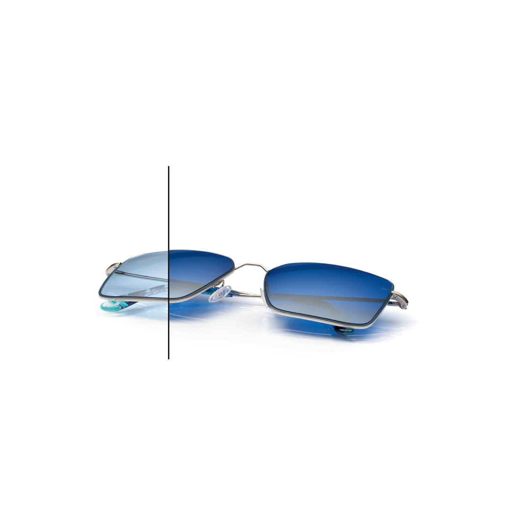 Gafas con lentes de ZEISS PhotoFusion X de color azul con protector espejado ZEISS DuraVision Flash de color diamante. La mitad de una lente no está totalmente oscurecida para mostrar la diferencia de color.