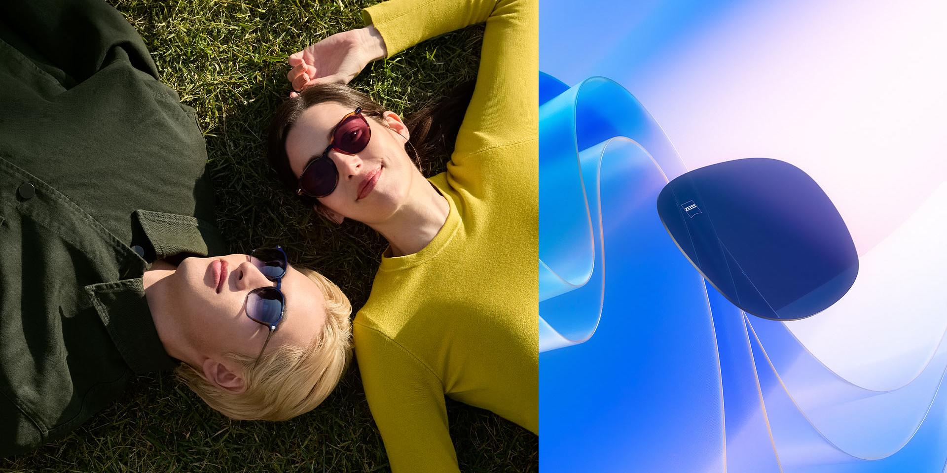 Hombre y mujer con gafas de sol graduadas ZEISS relajados en la hierba mirando al cielo. Se muestra una representación CGI de una lente tintada flotando hacia la luz del sol, lo que ilustra su capacidad para bloquear los rayos UV