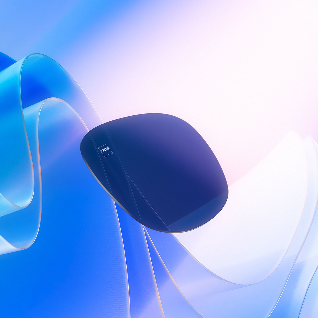 Se muestra una representación CGI de una lente tintada flotando hacia la luz del sol, lo que ilustra su capacidad para bloquear los rayos UV.