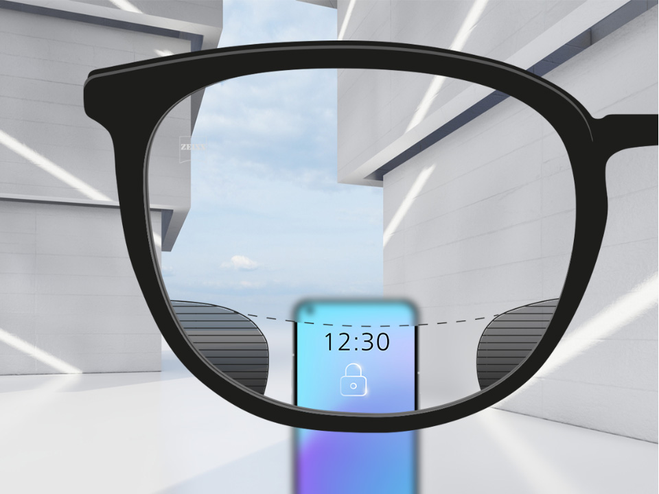 Una imagen con lentes ZEISS Digital SmartLife con un móvil y la lente totalmente nítida en la zona superior e inferior de la lente con zonas borrosas a izquierda y derecha.