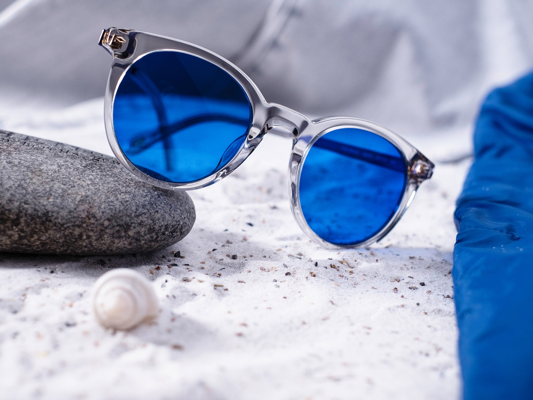 Imagen de un par de gafas de sol con tintado azul semicolocadas sobre una piedra