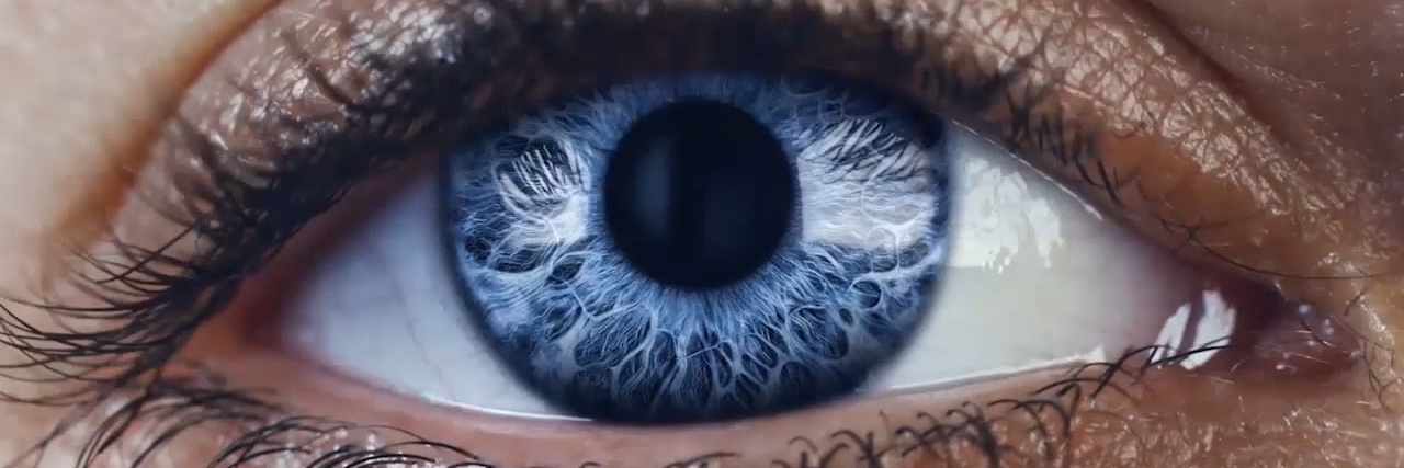 Líneas azules finas y abstractas sobre un fondo azul oscuro se mueven para formar la pupila y el iris de un ojo.
