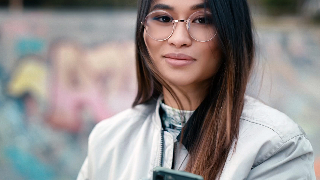 Una joven en un skate con lentes monofocales ZEISS SmartLife.